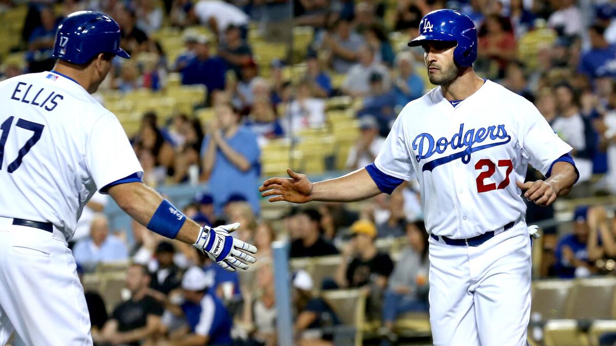 Dodgers left fielder Justin Ruggiano is congratulated by catcher A.J. Ellis after stealing third base and scoring a run on a throwing error by the Pirates in the first inning on Sept. 18.