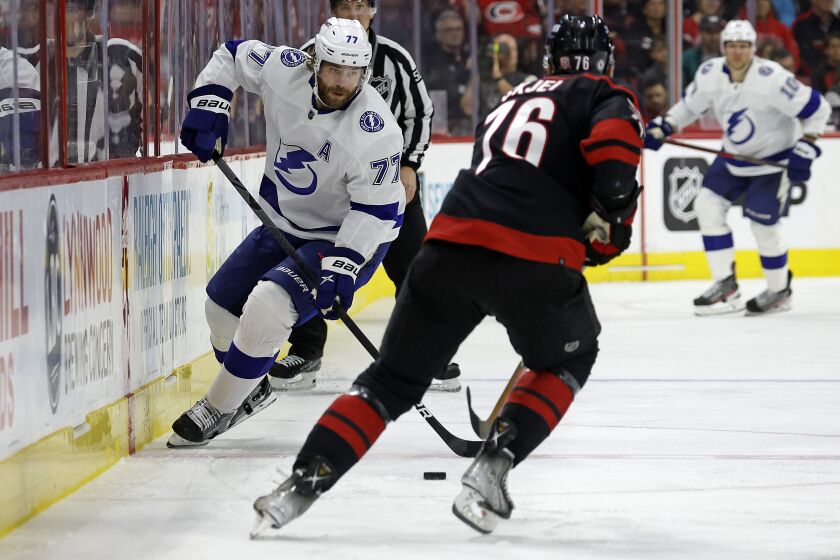 Tampa Bay Lightning's Victor Hedman (77) controls the puck in front of Carolina Hurricanes' Brady Skjei (76) during the first period of an NHL hockey game in Raleigh, N.C., Tuesday, March 28, 2023. (AP Photo/Karl B DeBlaker)