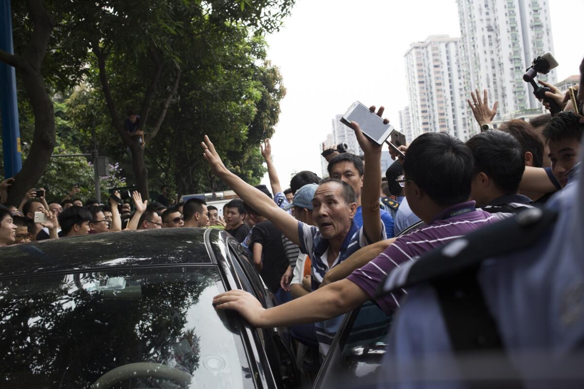 Uber drivers surround a private car and block the traffic on the Guangzhou Avenue in June. In China, ride-hailing startup Didi Kuaidi is rivaling Uber, with the on-demand transportation company announcing Wednesday it has raised $2 billion from investors.