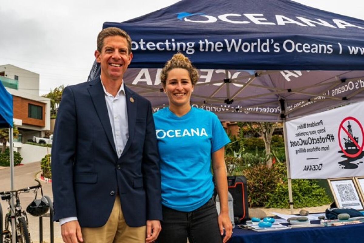Melissa Morris stands with U.S. Rep. Mike Levin (D-San Juan Capistrano) at a Hands Across the Sand conservation event in May.