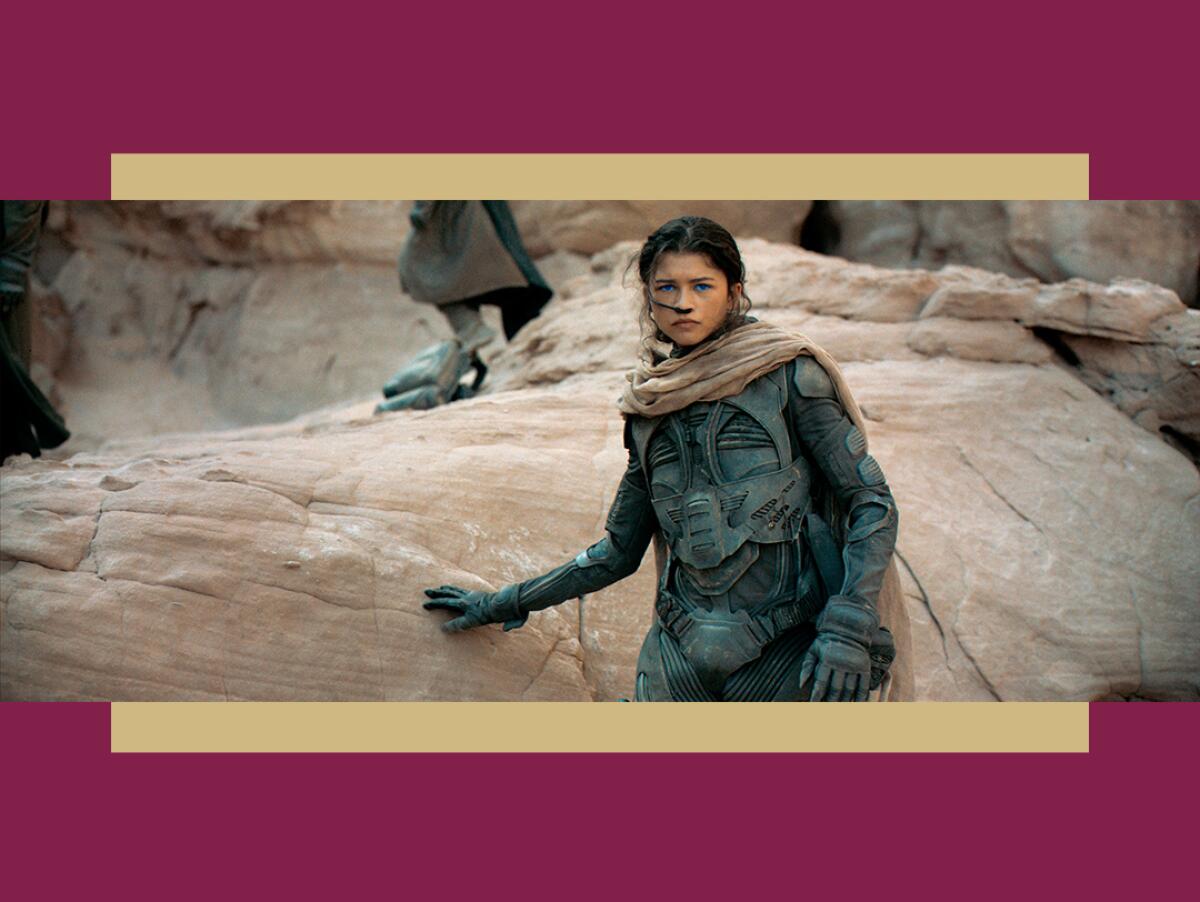 Zendaya stands next to a rock in a scene from “Dune.”