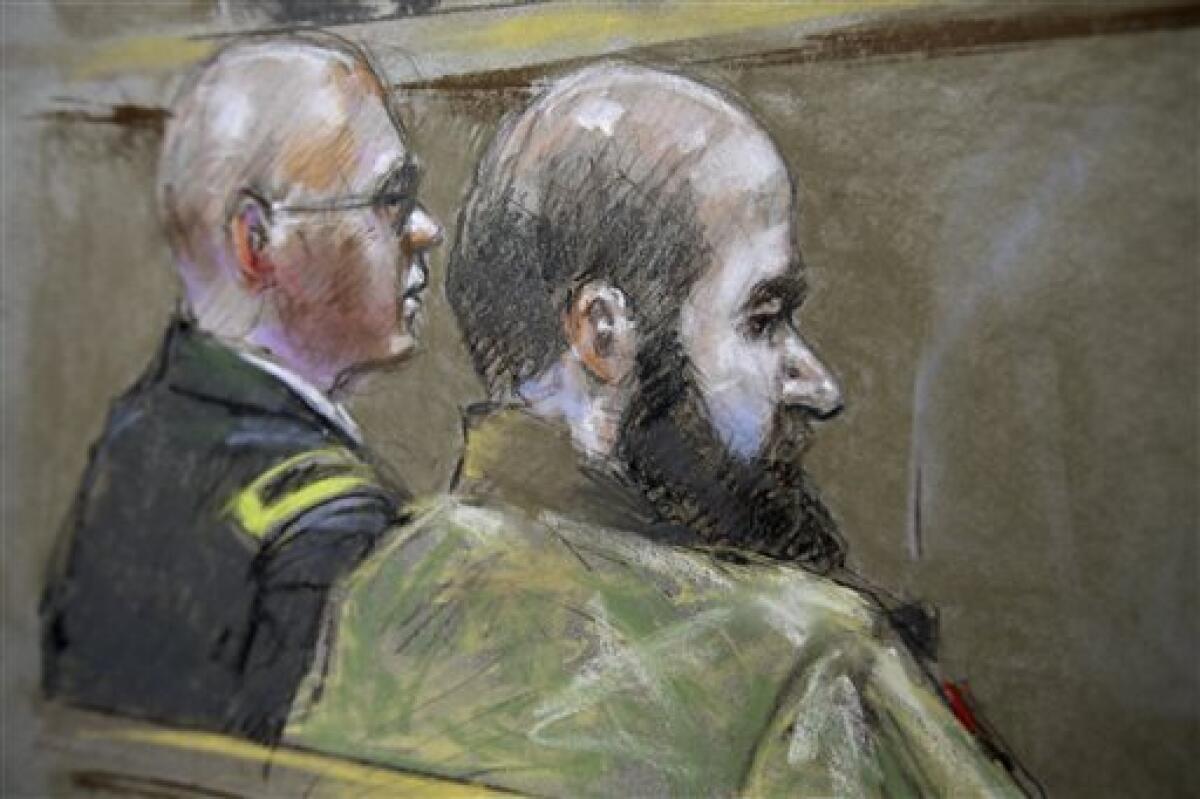 U.S. Army Maj. Nidal Malik Hasan, in beard, is shown with a military attorney who is advising him, Lt. Col. Kris Poppe, at Fort Hood, Texas, during Hasan's court-martial. Hasan is charged with killing 13 people and wounding 32 during a rampage at the Ft. Hood Army base in 2009.
