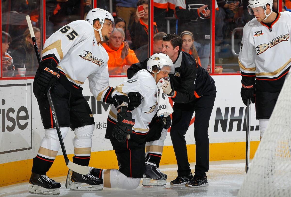 Teemu Selanne of the Anaheim Ducks is tended to by trainer Joe Huff and teammate Emerson Etem after an injury in the third period against the Philadelphia Flyers on Oct. 29 in Philadelphia.