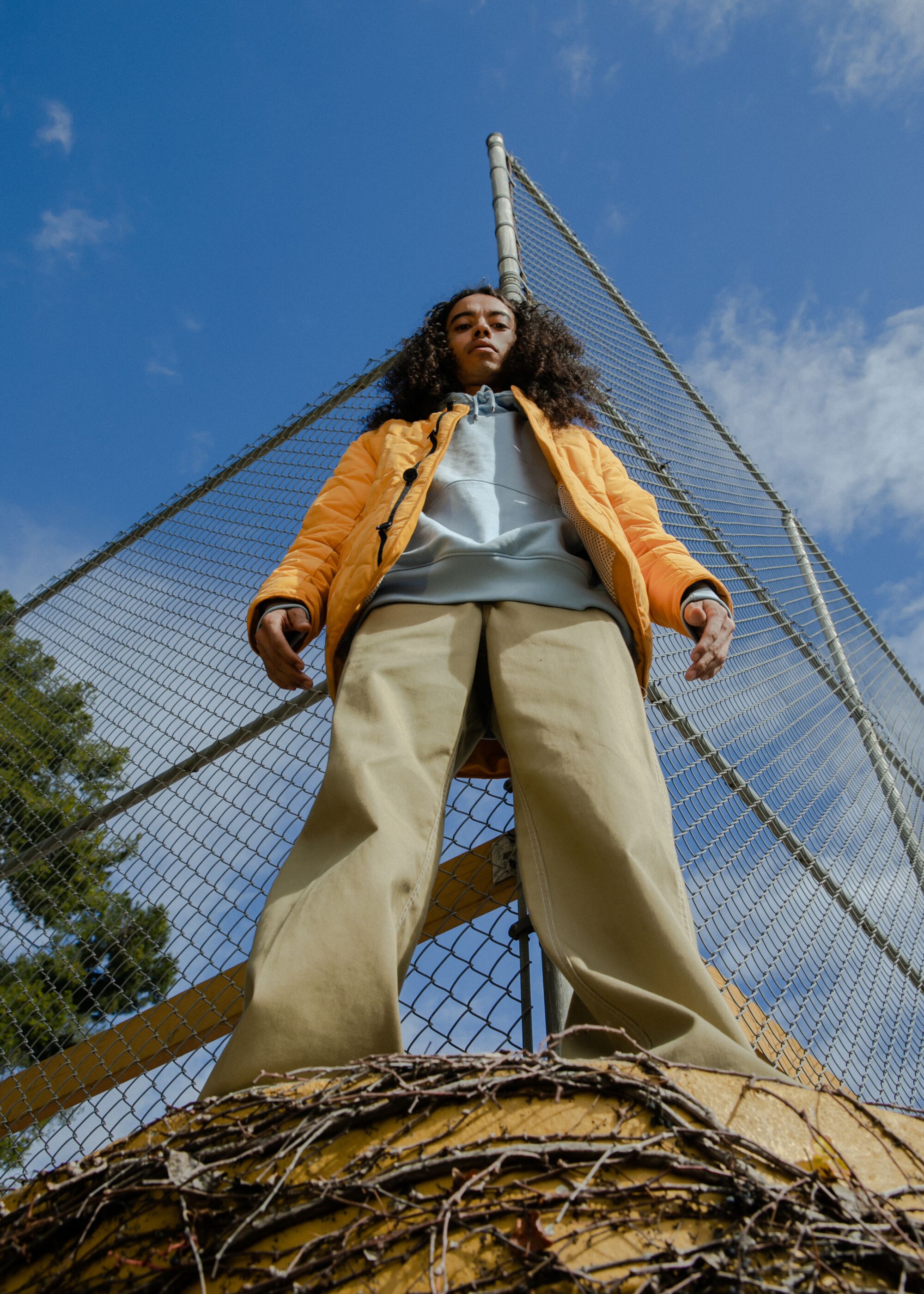 Model stands in front of basketball court.