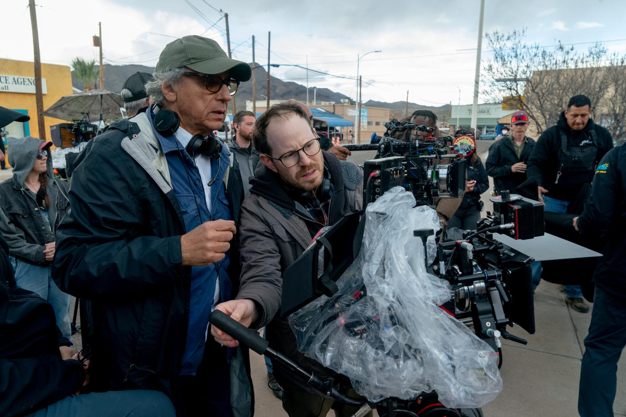 A cinematographer and a director line up a shot on a film set.