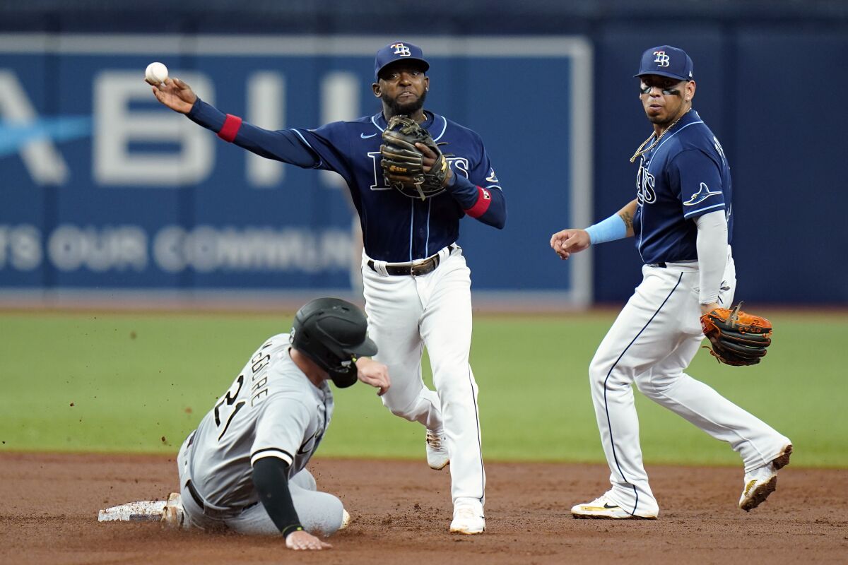 Tampa Bay Rays shortstop Vidal Brujan, center, forces Chicago White Sox's Reese McGuire, left, at second base and relays the throw to first in time to turn a double play on Leury Garcia during the third inning of a baseball game Saturday, June 4, 2022, in St. Petersburg, Fla. Looking on is second baseman Isaac Paredes. (AP Photo/Chris O'Meara)