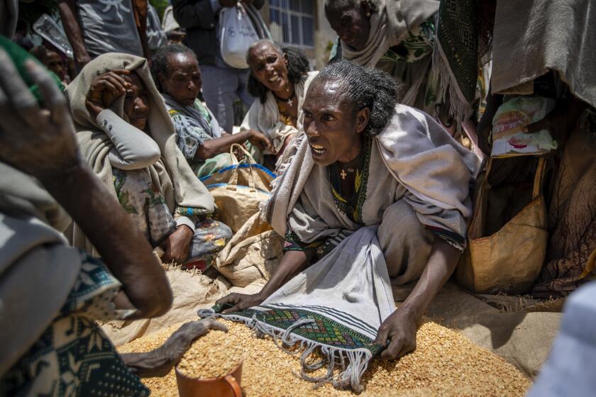 FILE - An Ethiopian woman argues with others over the allocation of yellow split peas after it was distributed by the Relief Society of Tigray in the town of Agula, in the Tigray region of northern Ethiopia, on May 8, 2021. In 2023 urgently needed grain and oil have disappeared again for millions caught in a standoff between Ethiopia's government, the United States and United Nations over what U.S. officials say may be the biggest theft of food aid on record. (AP Photo/Ben Curtis, File)