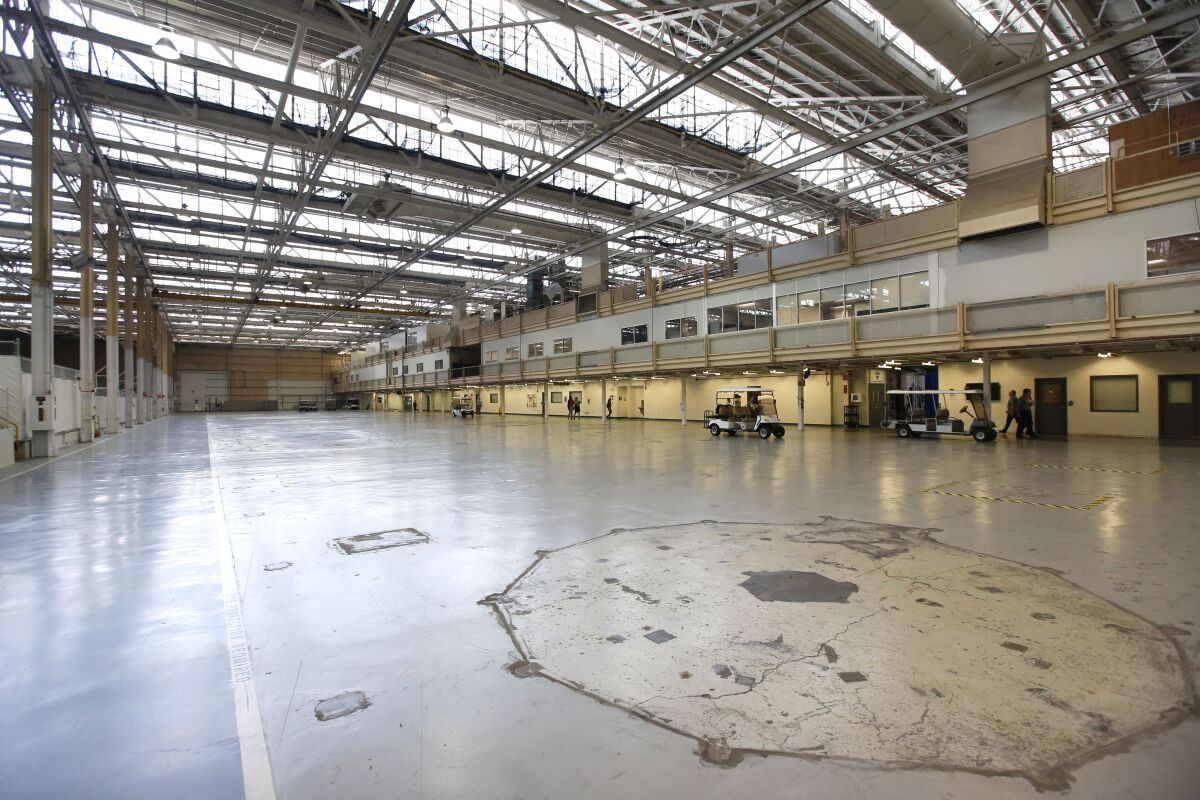 A photo of the inside of a NAVWAR hangar shows a cavernous space that is underutilized and considered obsolete by the Navy.