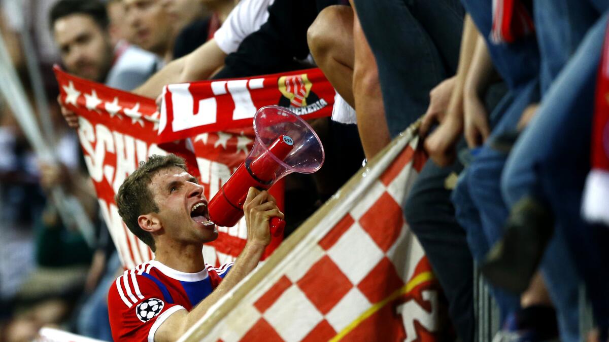 Thomas Mueller celebrates with Bayern Munich fans after a 6-1 victory over FC Porto in a Champions League game at the Allianz Arena in 2015.