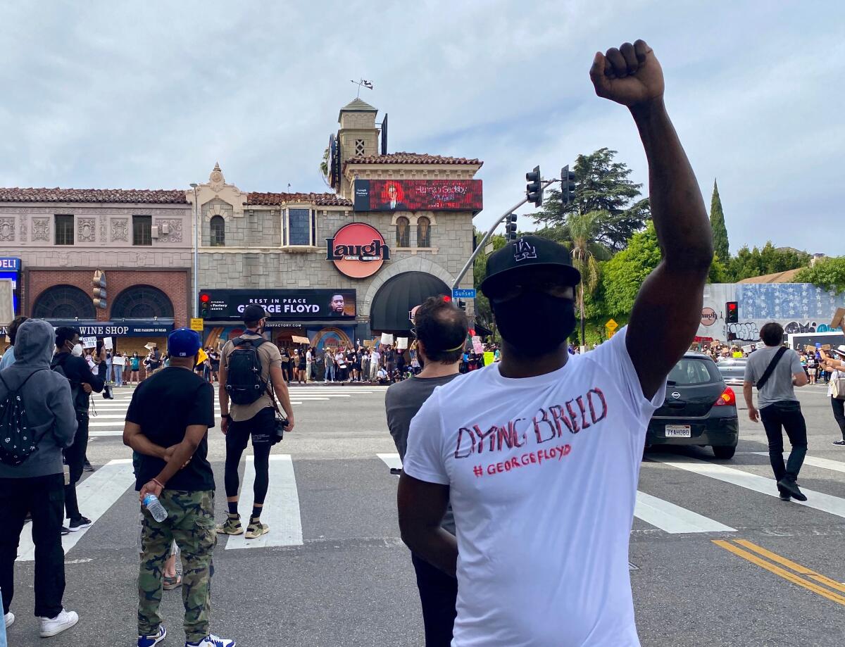 Sean Welch, 40, protests the death of George Floyd at Laurel Avenue and Sunset Boulevard on Monday.