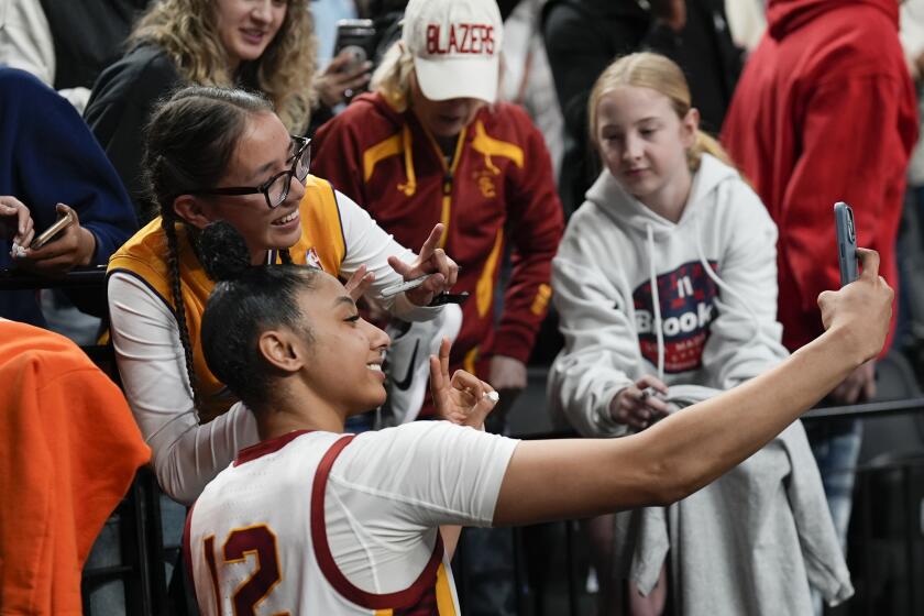 USC guard JuJu Watkins poses for a photo with a fan after the Sweet 16 win over Baylor on March 30, 2024.