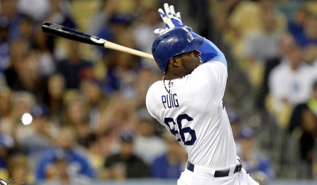 Dodgers right fielder Yasiel Puig follows through on a hit against the Colorado Rockies during a game last month at Dodger Stadium.
