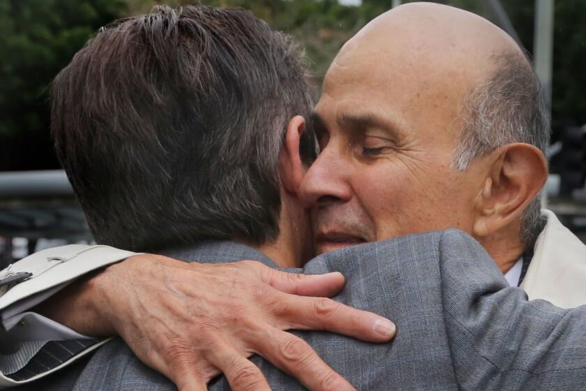 Former Los Angeles County Sheriff Lee Baca hugs his lawyer, Nathan Hochman, outside court last month.