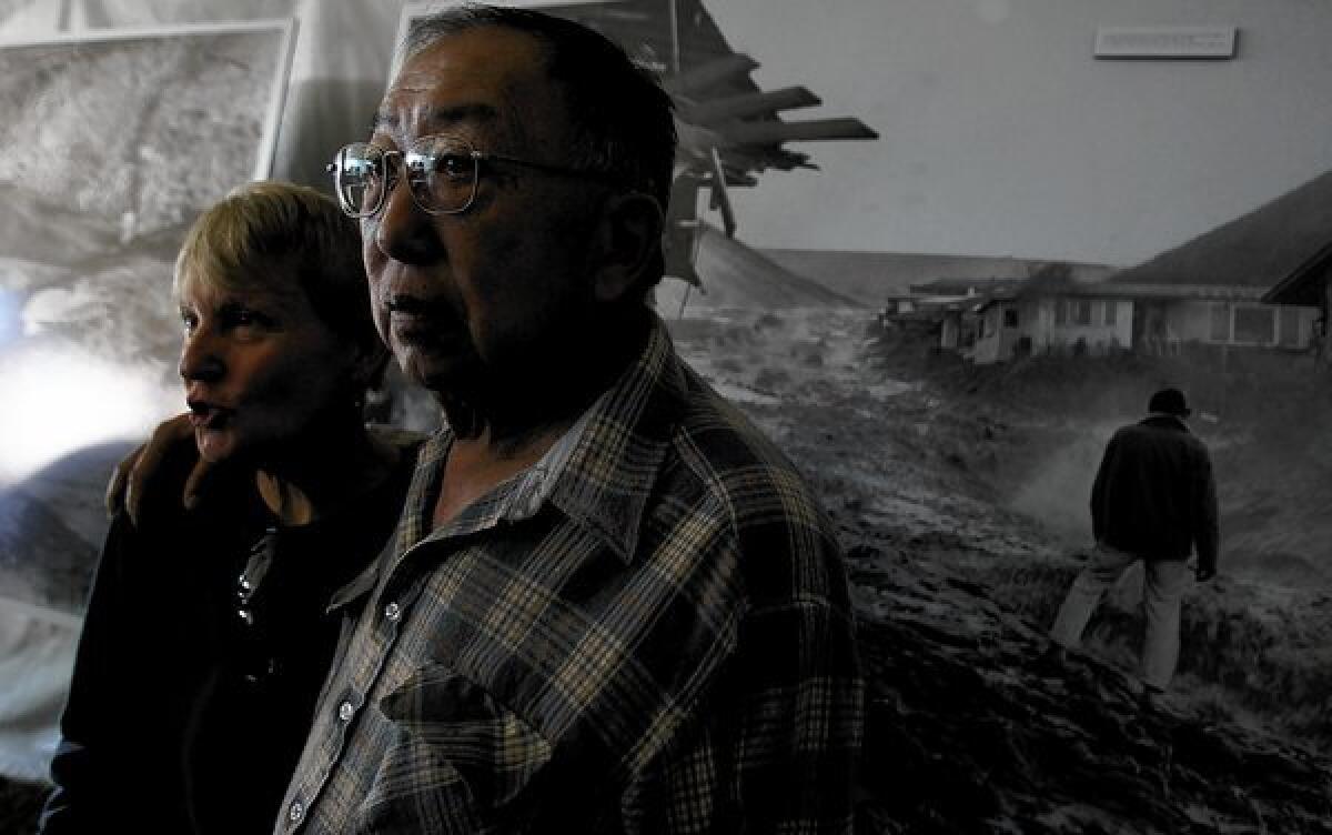 Ruth and Fred Kong look at large photo reproductions during a commemoration of the 50th anniversary of the collapse of the Baldwin Hills Reservoir dam, held at the Upper Kenneth Hahn State Recreation Area. The flood killed five people and destroyed 65 homes. Fred Kong witnessed the devastation and helped recover the bodies of two victims.