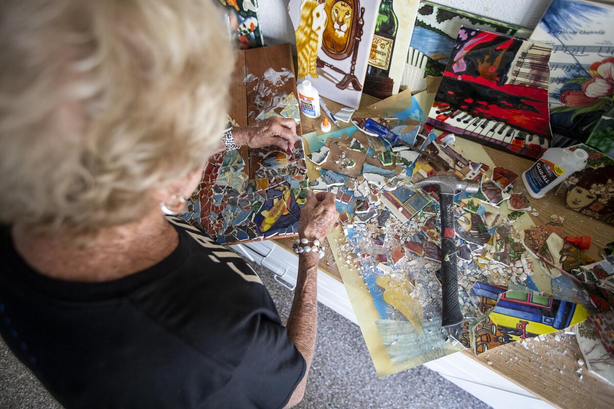 Robbie Britvich, 82, places a piece of tile into a piece.