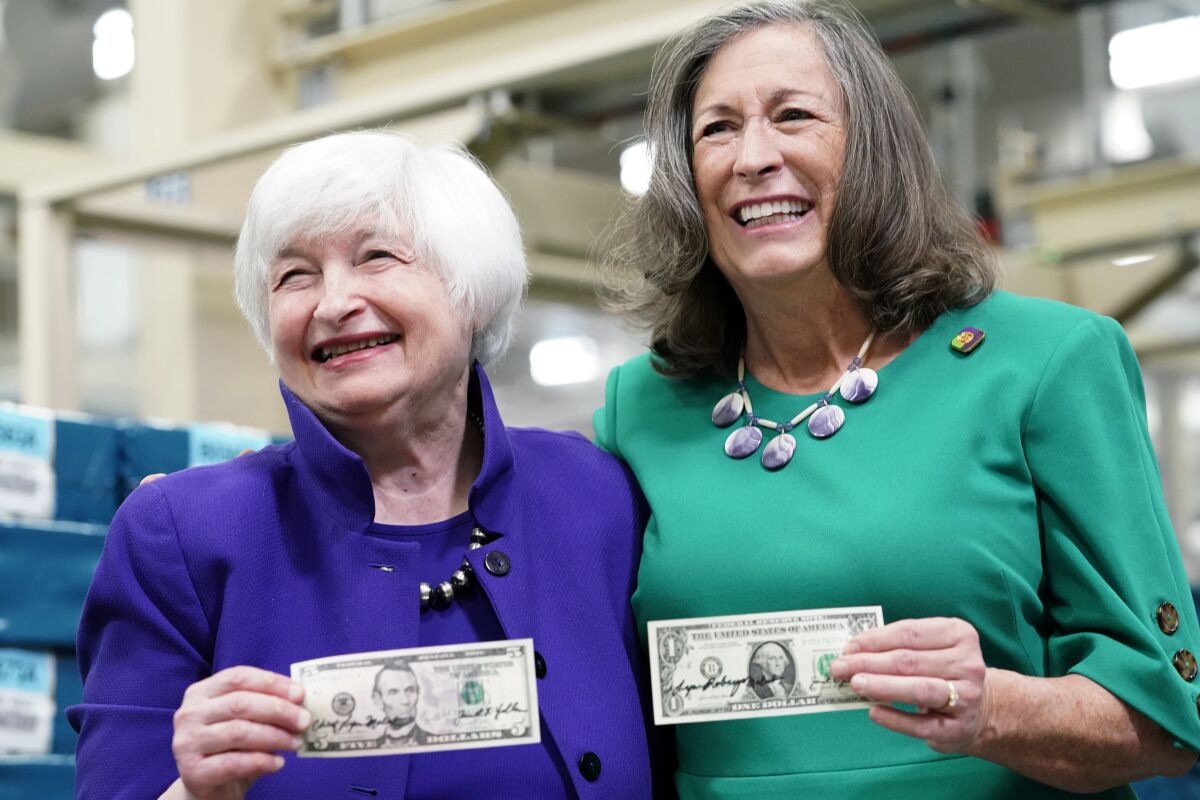 Secretary of the Treasury Janet Yellen, left, and Treasurer of the United States Chief Lynn Malerba show of money they autographed during a tour of the Bureau of Engraving and Printing's (BEP) Western Currency Facility in Fort Worth, Texas, Thursday, Dec. 8, 2022. Yellen unveiled the first U.S. currency bearing her signature, marking the first time that U.S. bank notes will bear the name of a female treasury secretary. (AP Photo/LM Otero)