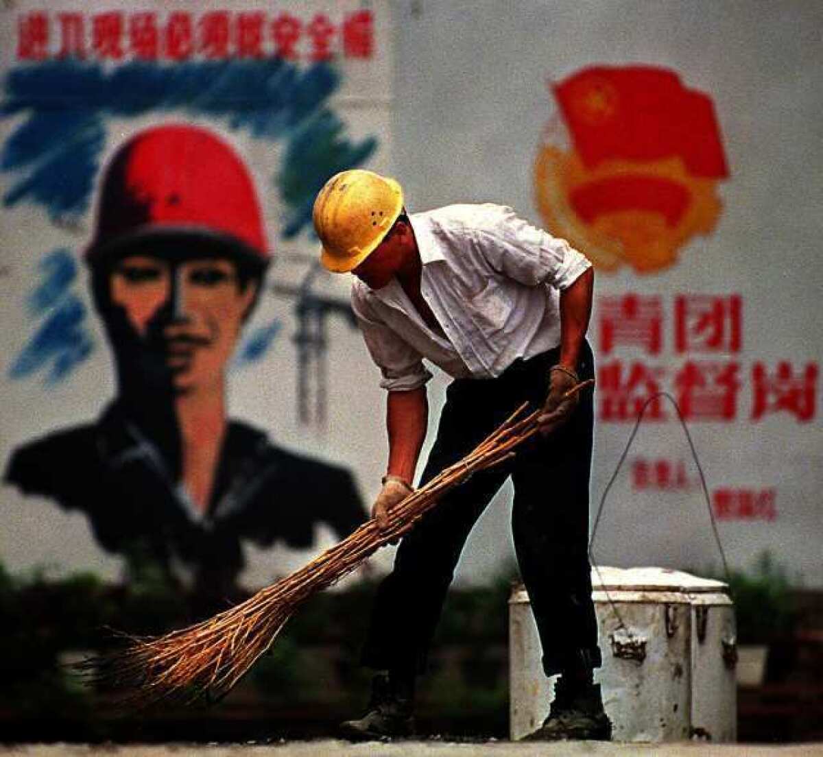 A worker sweeps in downtown Beijing. The World Bank says that China's downturn is headed for a "soft landing"