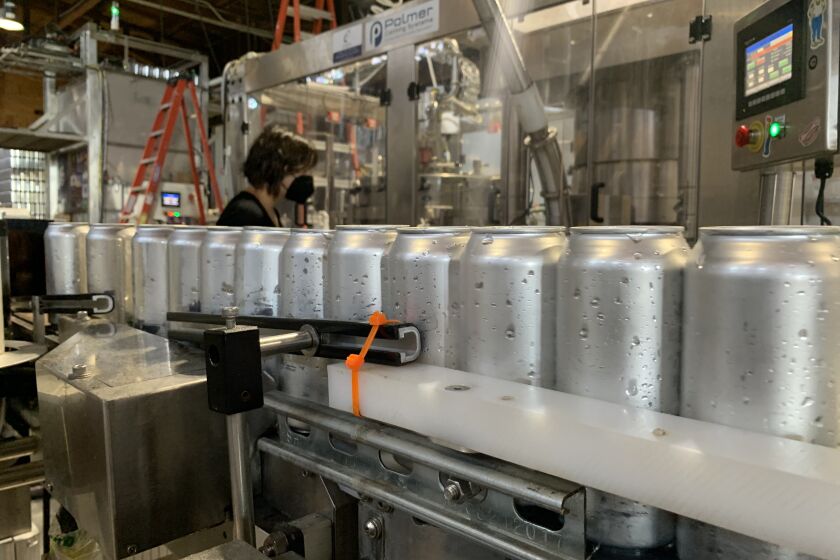 Aluminum cans make their way down the canning line at Almanac Beer Co. in Alameda, California. 