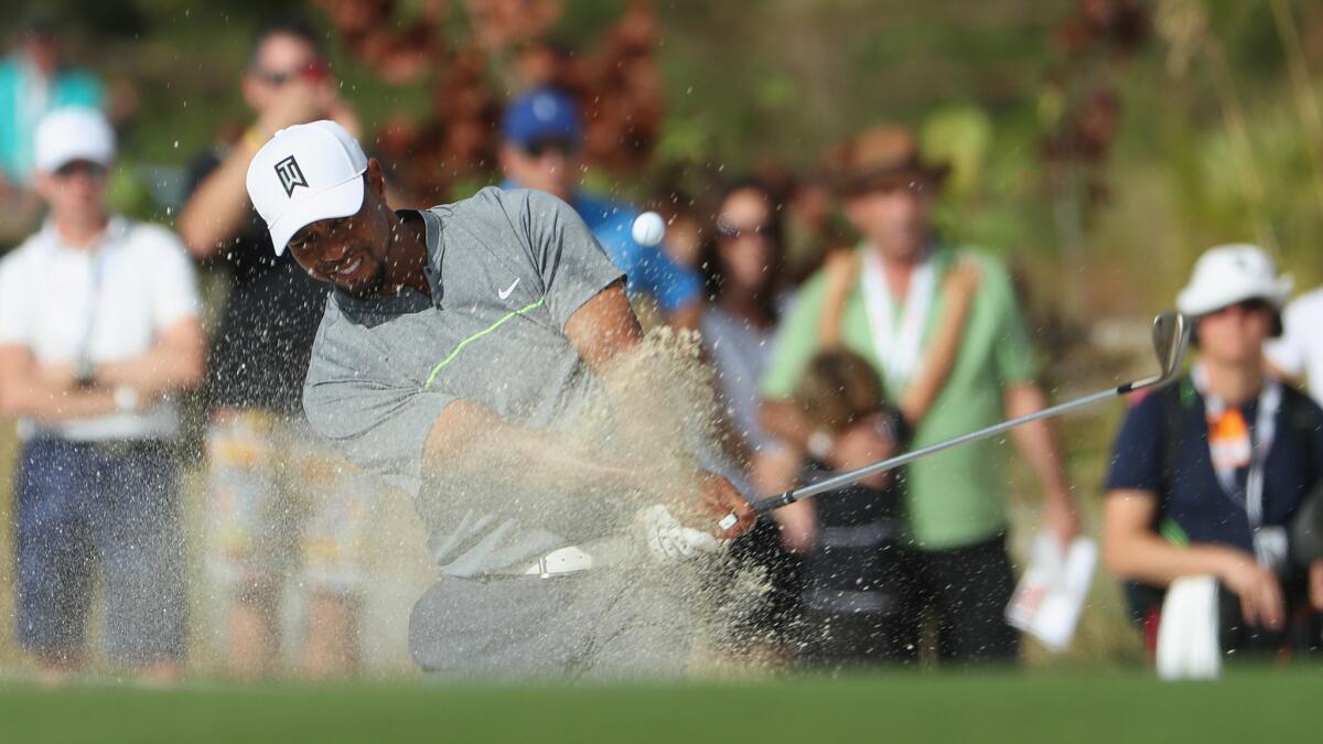 Tiger Woods hits out of a greenside bunker at No. 11 during the third round of the Hero World Challenge on Saturday.