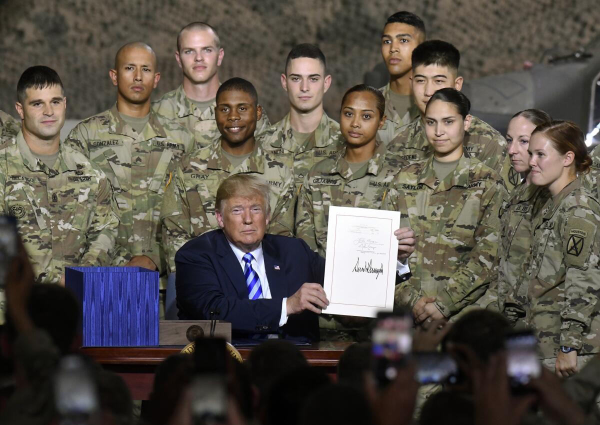 President Trump signs the John McCain National Defense Authorization Act at Ft. Drum, N.Y., on Aug. 13.