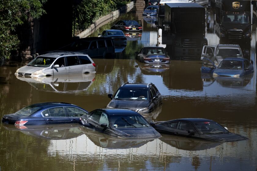 Cars and trucks float in high water on an inundated highway