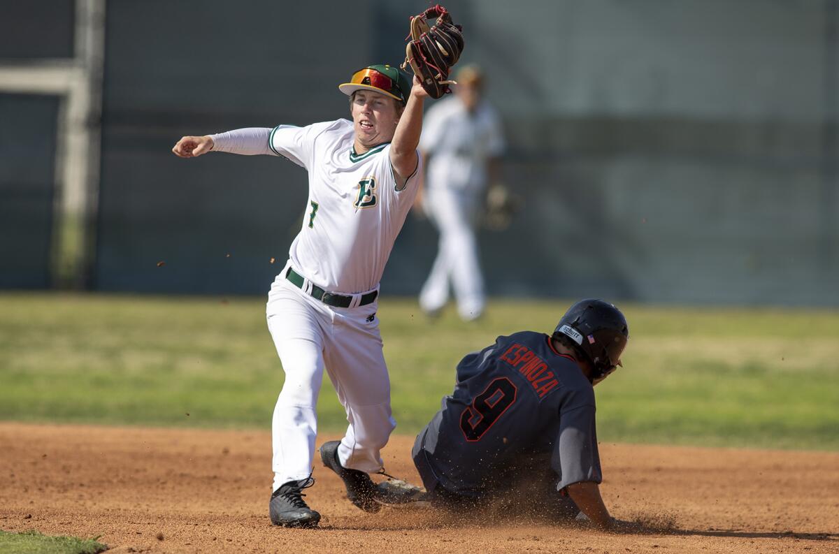 Huntington Beach's Aiden Espinoza steals second against Edison's Dylan Richardson during Friday's game.