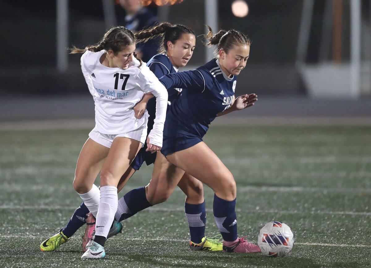 Corona del Mar's Isabella Thomas (17) battles Newport's Camryn Netzer (12) at midfield.