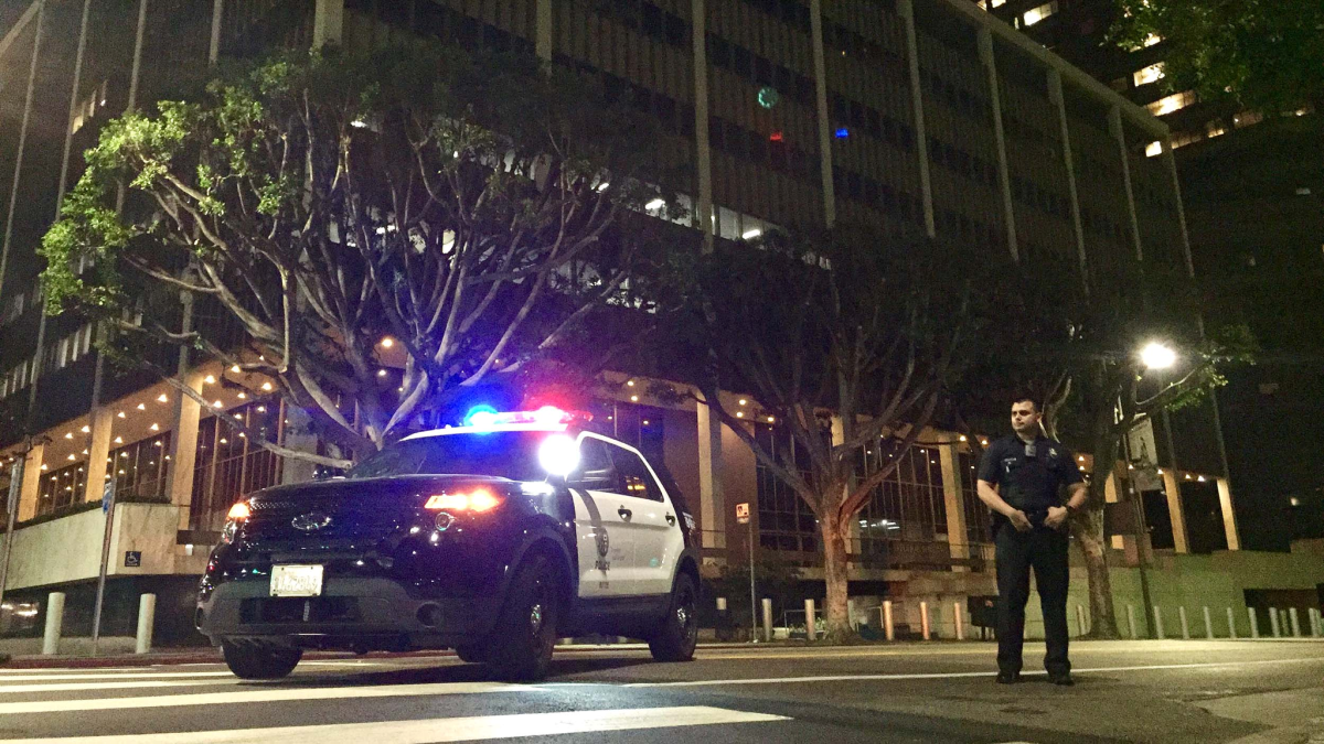 A Los Angeles police officer keeps watch at Temple and Los Angeles streets, near where a suspicious package forced the evacuation of a downtown federal building.