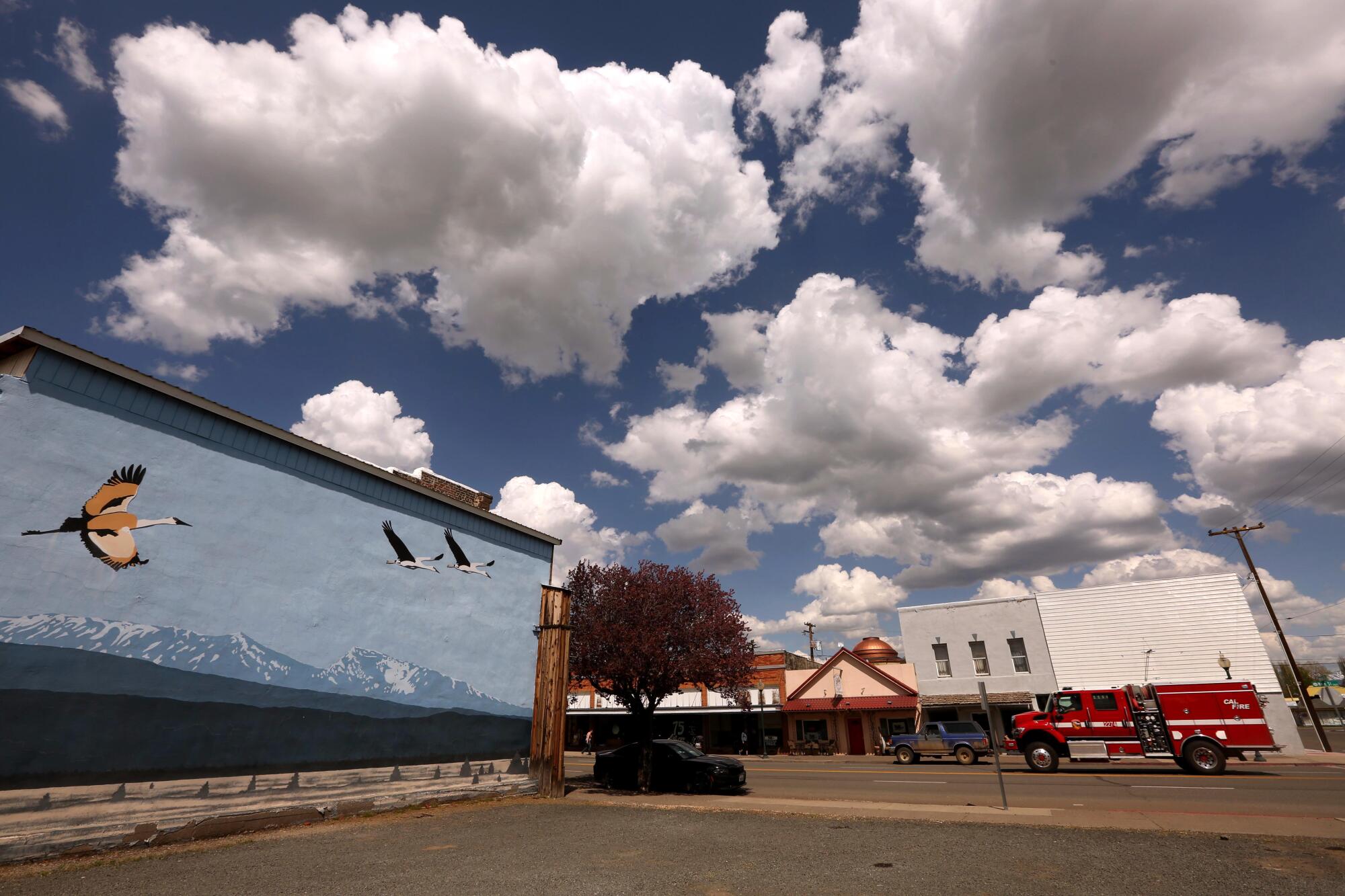A firetruck makes its way down Main Street against a backdrop of clouds in downtown Alturas.