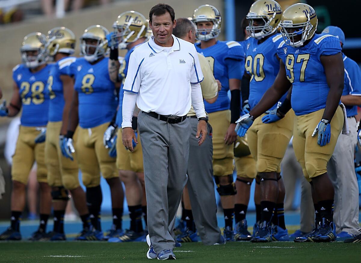 UCLA Coach Jim Mora watches his players warm up before the Bruins' season opener against Nevada last month.