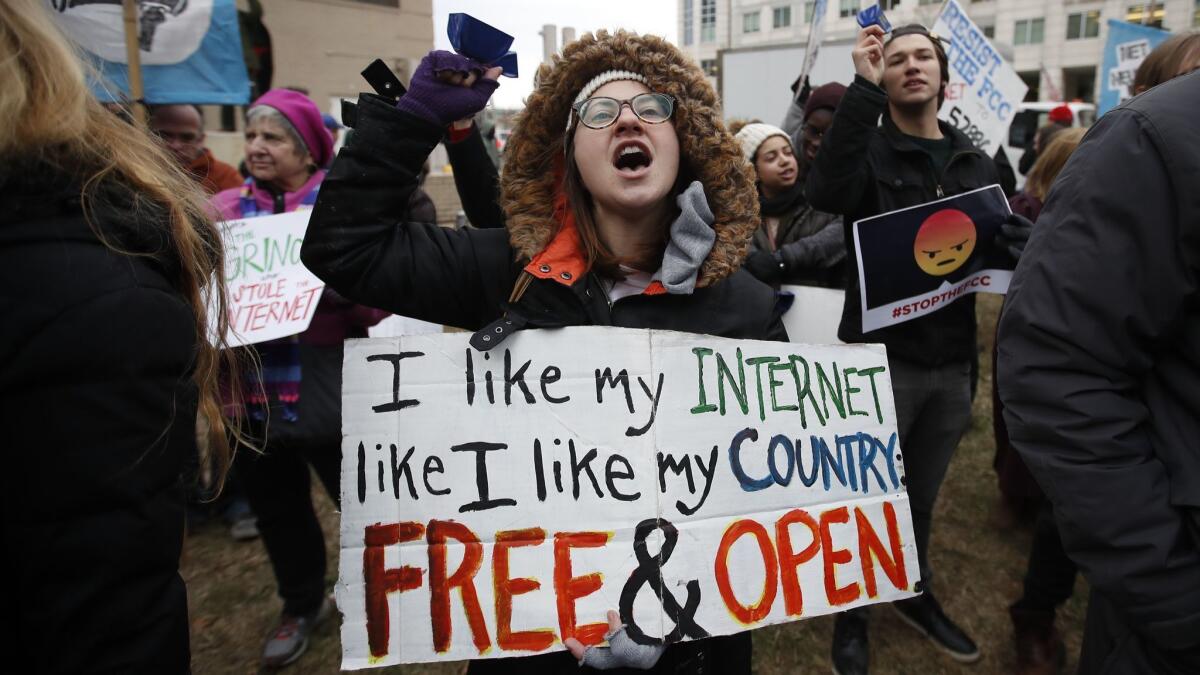 In this Dec. 14, 2017, file photo, Lindsay Chestnut of Baltimore holds a sign as she protests the repeal of net neutrality regulations outside the headquarters of the Federal Communications Commission in Washington, D.C.