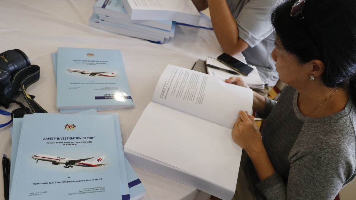 Copies of the final investigation report on missing flight MH370 are offered to the media in Putrajaya on Monday.