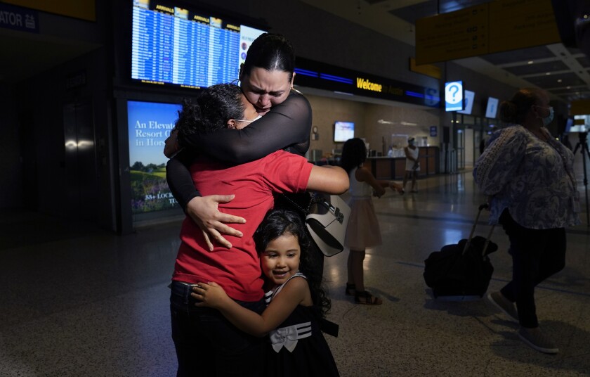Emely, left, is reunited with her mother, Glenda Valdez and sister, Zuri, at Austin-Bergstrom International Airport, Sunday, June 6, 2021, in Austin, Texas. It had been six years since Valdez said goodbye to her daughter Emely in Honduras. Then, last month, she caught a glimpse of a televised Associated Press photo of a little girl in a red hoodie and knew that Emely had made the trip alone into the United States. On Sunday, the child was returned to her mother’s custody. (AP Photo/Eric Gay)