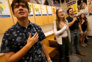 ALTURAS, CA - MAY 17, 2023 - Seniors Justin Walton, from left, Linda Plumlee and other students say the Pledge of Allegiance at the start of the school day in their Economy class at Modoc High School in Alturas, California, on May 17, 2023. Plumlee, class president, emancipated herself from her mother at age 15 because of her tough upbringing. Since emancipation Plumlee has been couch surfing, living in her car and now lives with a couple and their children in Alturas. Plumlee is one of many students in rural California schools who have been experiencing a high rate of Adverse Childhood Experiences (ACE). She will be attending UC Berkeley in the Fall. (Genaro Molina / Los Angeles Times)