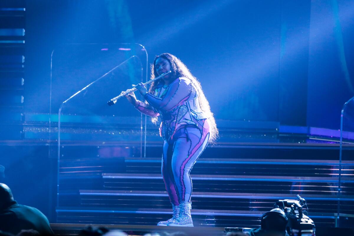Lizzo performs, flute included, at the 62nd Grammy Awards.