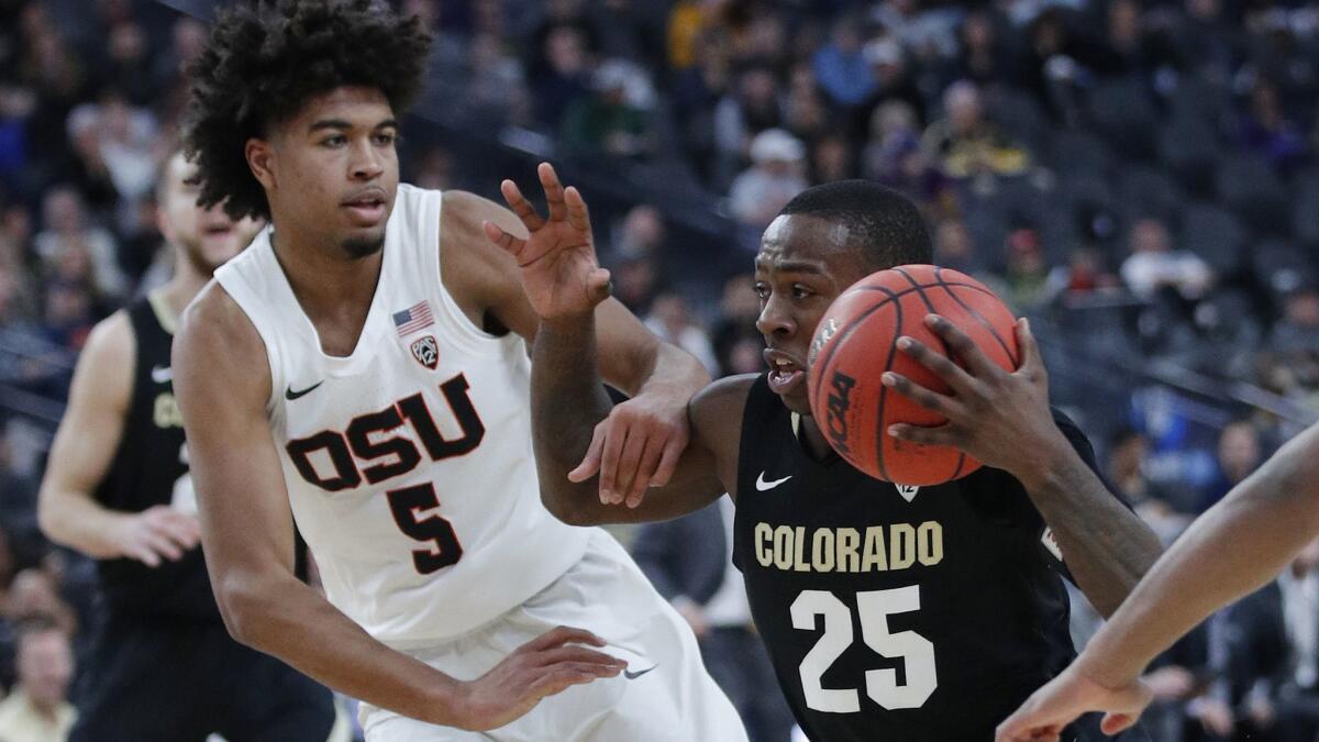 Colorado's McKinley Wright IV drives around Oregon State's Ethan Thompson during the first half in the quarterfinals of the Pac-12 men's tournament on Thursday in Las Vegas.