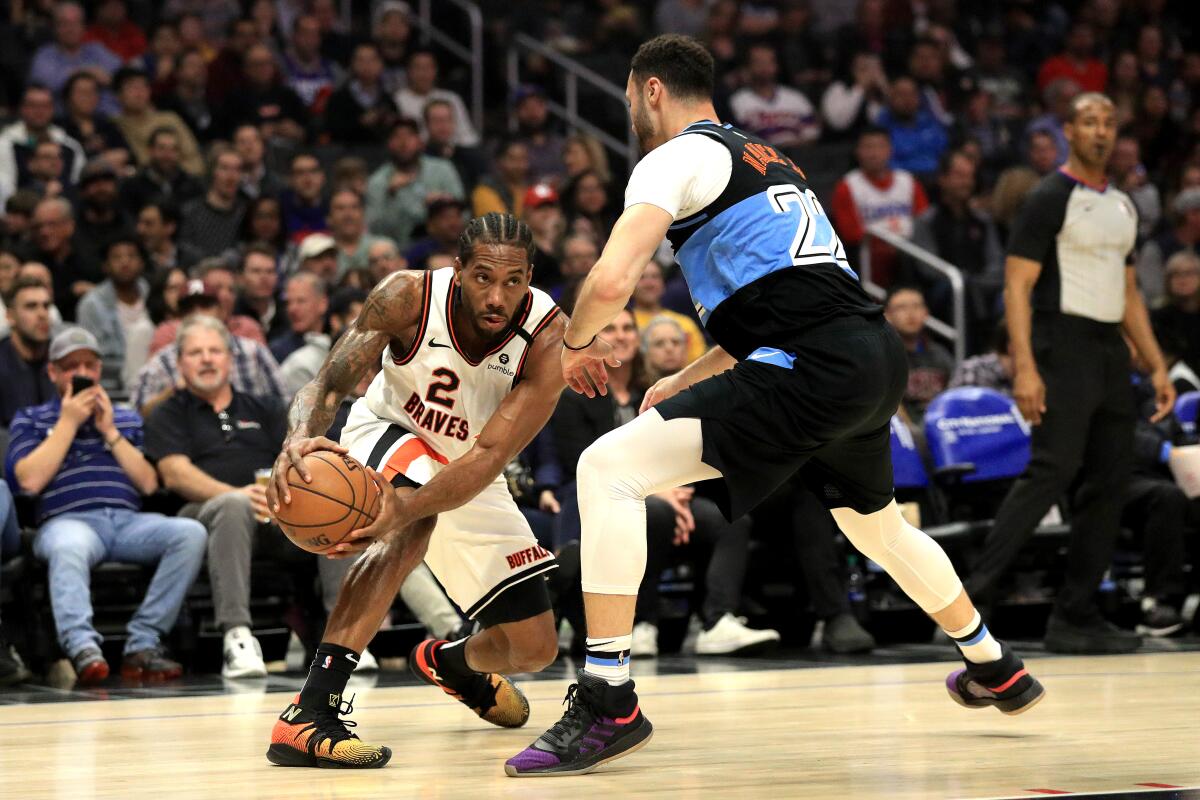 Cleveland Cavaliers' Larry Nance Jr. (22) defends against the dribble of Clippers' Kawhi Leonard (2) during the first half at Staples Center on Tuesday.