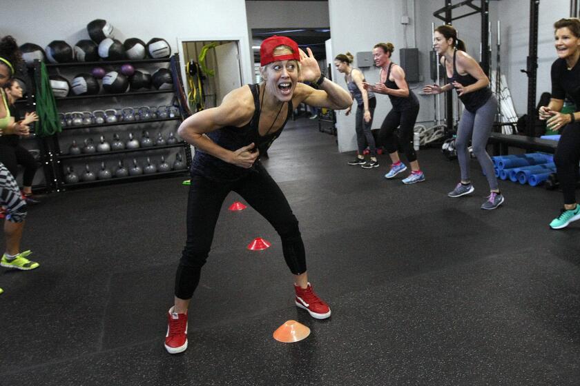 Fitness trainer Lacey Stone, center, leads her students through an exercise during a session of their two-week boot camp class at Lock Box L.A. on Pico Boulevard.