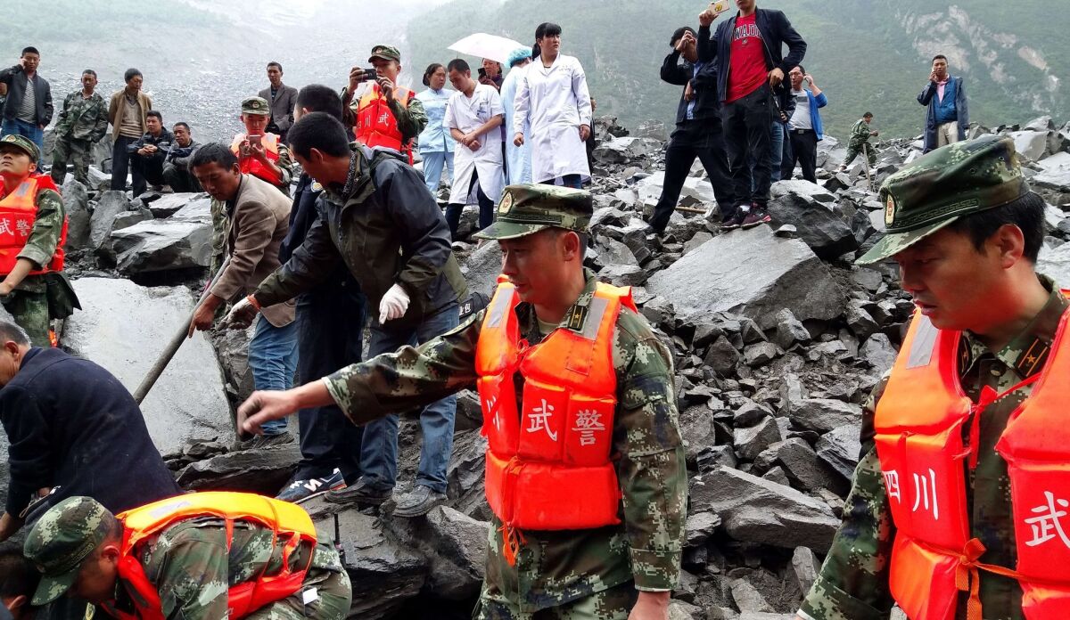 Rescuers work at the site of a massive landslide Saturday in Maoxian county, southwest China.