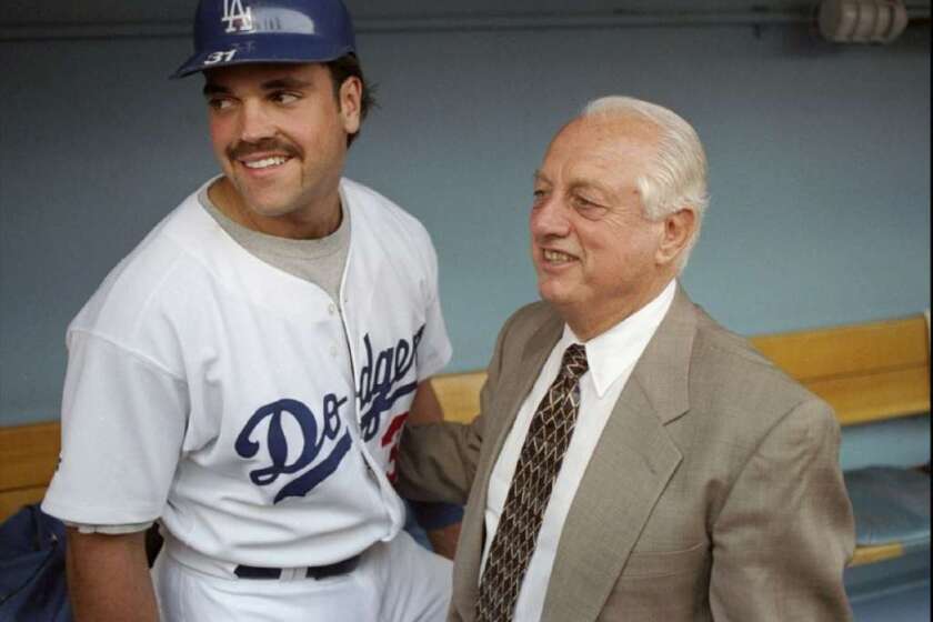 Mike Piazza stands with Tommy Lasorda in the Dodgers dugout in 1997.