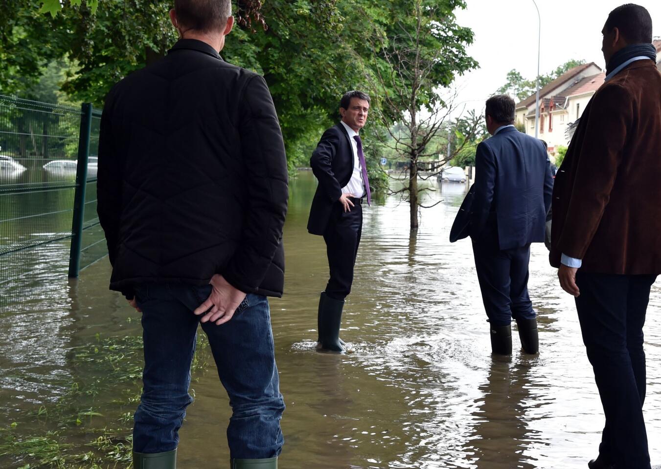 French Prime Minister Manuel Valls, second from left, visits flooded areas in Crosne on June 4, 2016, in a southern Paris suburb.