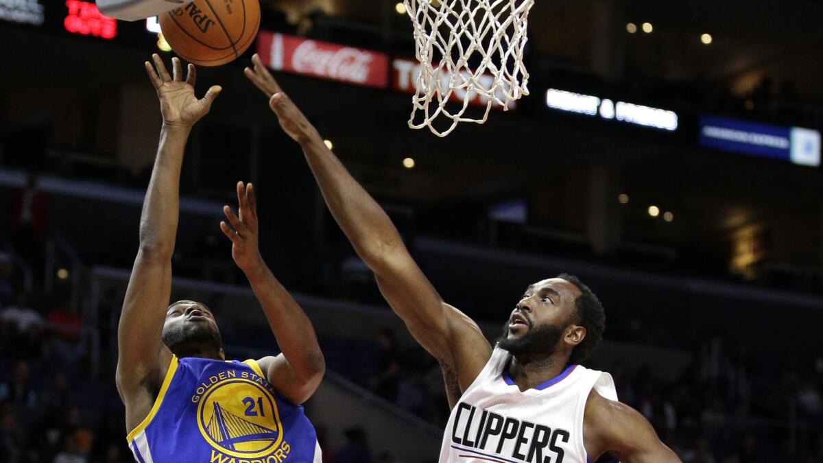 Clippers forward Luc Mbah a Moute tries to block a shot by Warriors guard Ian Clark during a preseason game Oct. 20.