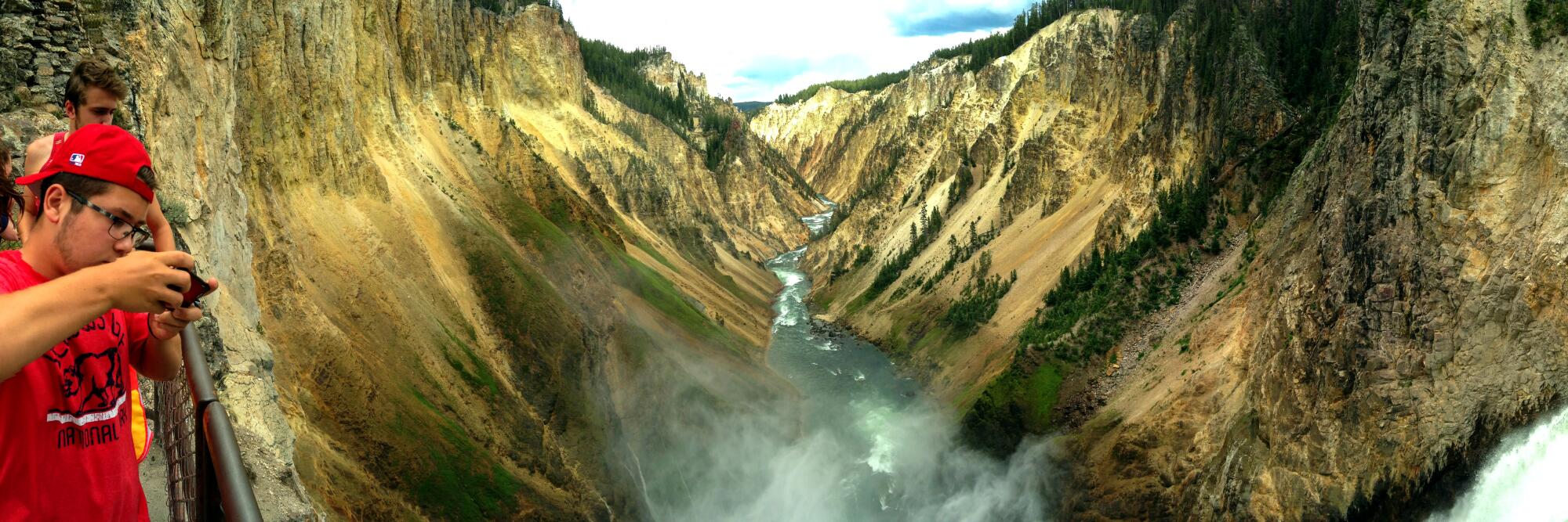 Grand Canyon of the Yellowstone, Yellowstone National Park, with two people looking over a rail at water running past below.