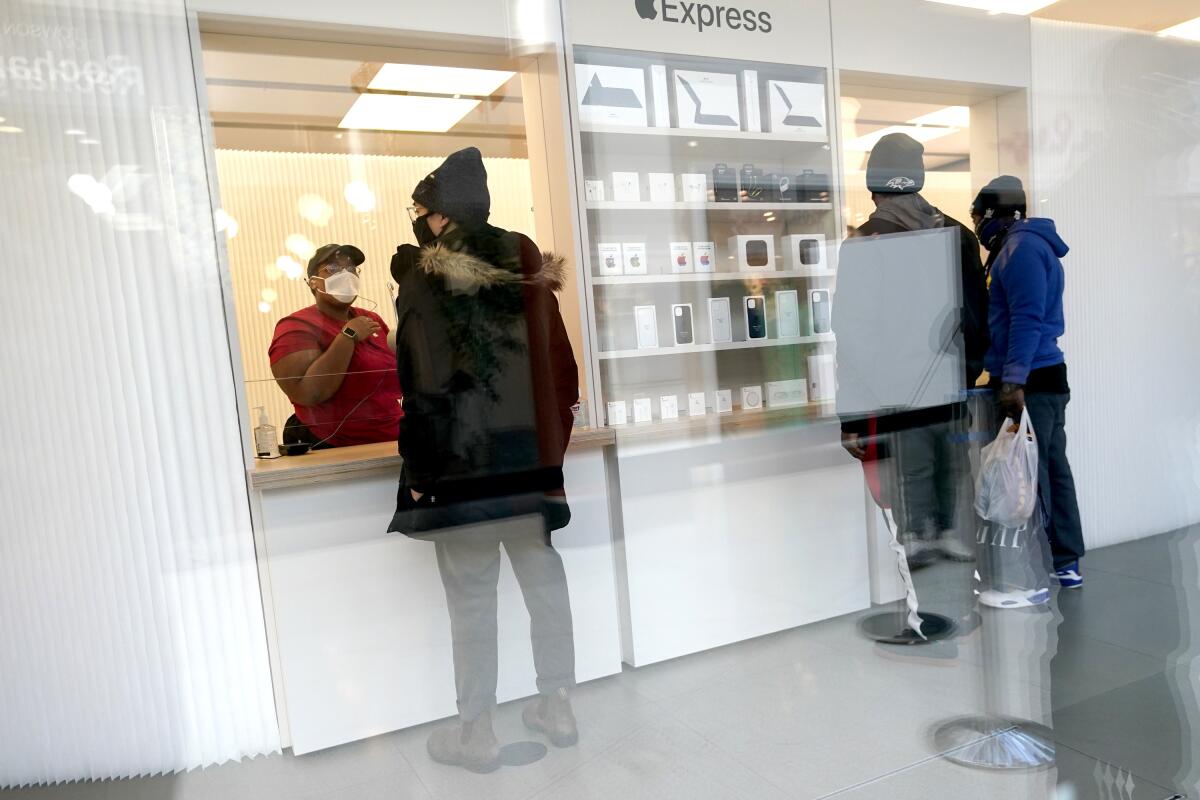 Customers pick up orders at an Apple store counter