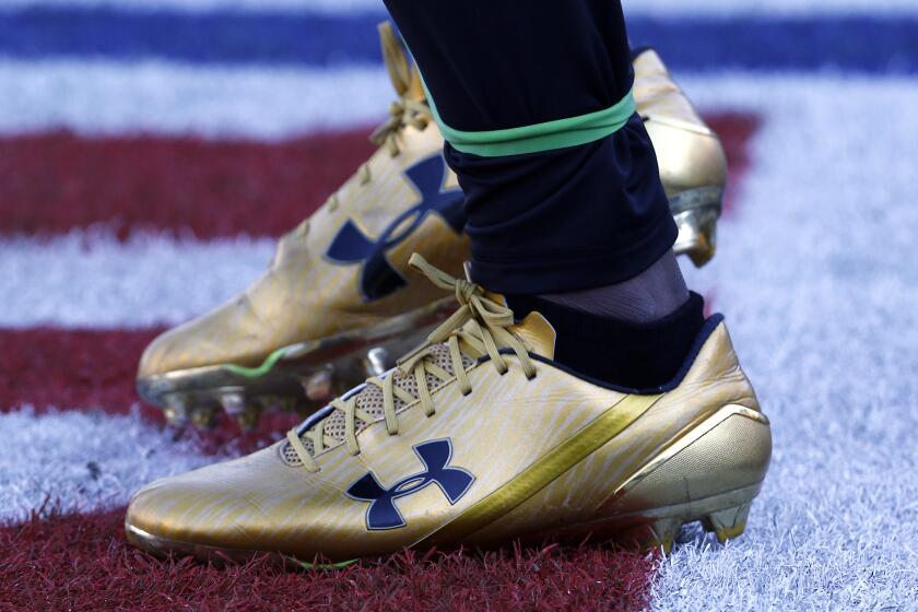 FILE- In this Dec. 10, 2017, file photo Jacksonville Jaguars running back T.J. Yeldon warms up wearing Under Armour cleats before an NFL football game against the Seattle Seahawks in Jacksonville, Fla. A strong quarter from Under Armour is being overshadowed by a federal investigation into the company’s accounting practices. The athletic gear maker reported better than expected profit and revenue for the third quarter Monday, Nov. 4, 2019, but shares are down 13% before the opening bell. (AP Photo/Stephen B. Morton, File)