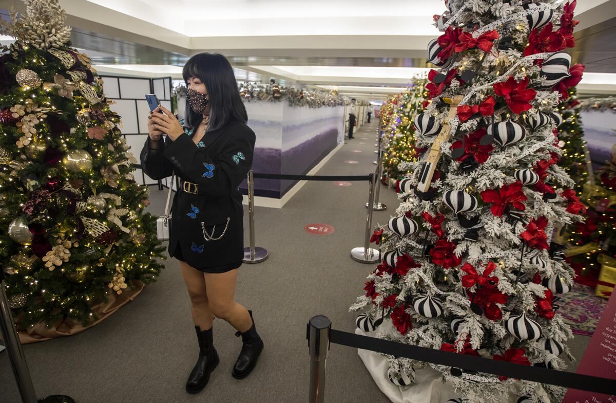 Maggie Chen takes photos of some of the 36 holiday trees at South Coast Plaza.