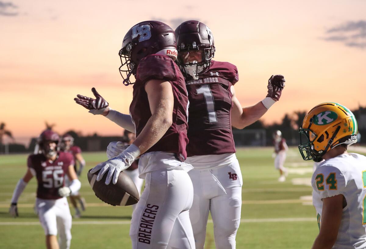 Laguna Beach's Charlie Hunt (1) congratulates Redmond Chesley after he scored on a touchdown run.