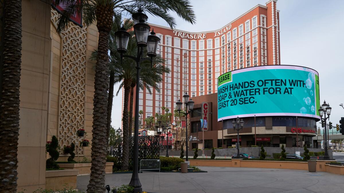 An electronic billboard outside the Treasure Island hotel and casino on the Las Vegas Strip shows a coronavirus warning instead of touting a show.