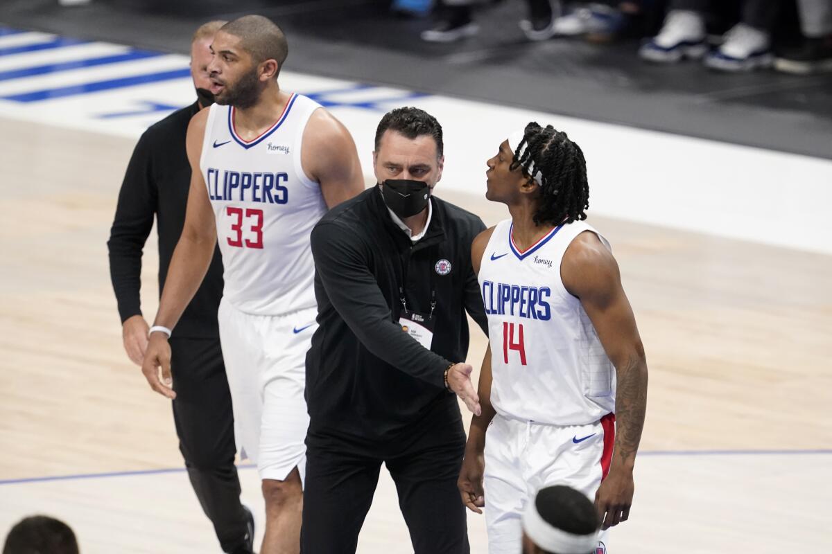 Clippers forward Nicolas Batum (33) and guard Terance Mann (14) are held back by staff during a Game 3 skirmish with Dallas.