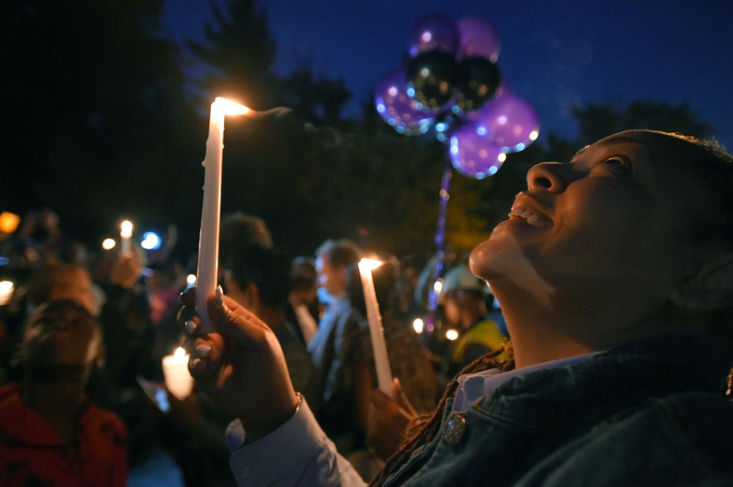 MTA employee Vita Burnett watches as a lantern takes off above the crowd during a vigil for those killed in a crash between an MTA bus and a yellow school bus.